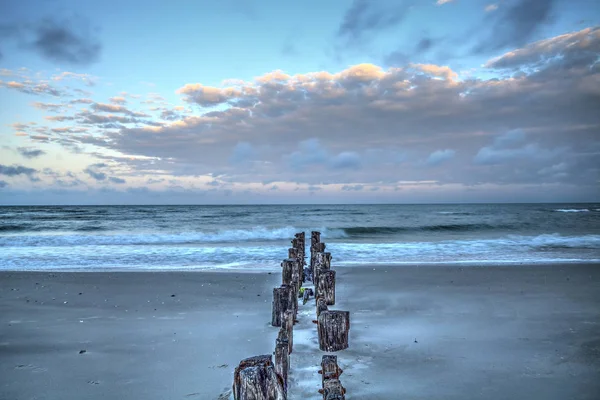 Amanecer sobre un muelle en ruinas en la playa de Port Royal — Foto de Stock