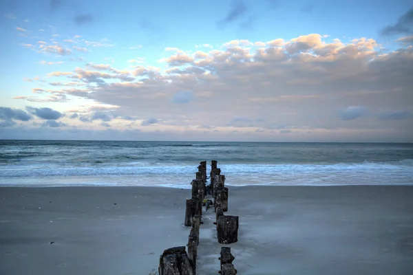 Amanecer sobre un muelle en ruinas en la playa de Port Royal — Foto de Stock