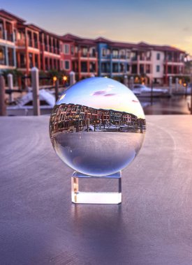 Crystal ball with colorful buildings and a harbor of boats along clipart