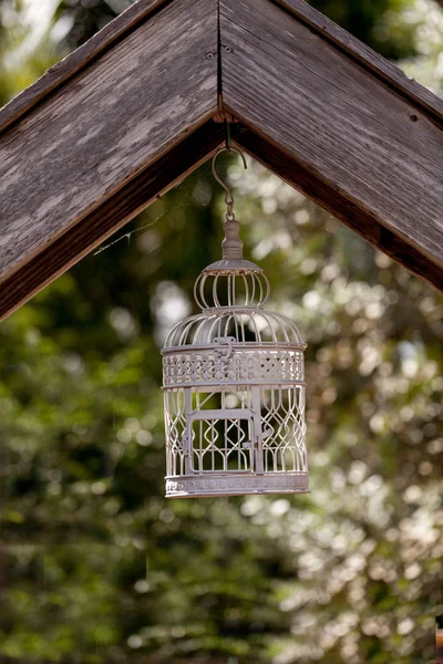 Птичий домик из белой проволоки висит в деревенском саду — стоковое фото