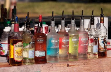 Renkli rom şişeleri bir barın önünde sıraya dizilmiş.