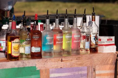 Renkli rom şişeleri bir barın önünde sıraya dizilmiş. 