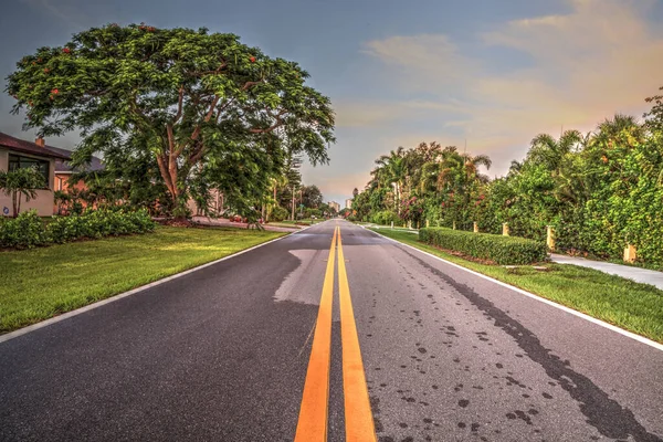 Stretch of road along Vanderbilt Drive in Naples Park, Naples, Florida at sunrise.