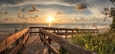 Boardwalk leading toward Delnor-Wiggins State Park at sunset in Naples, Florida. clipart