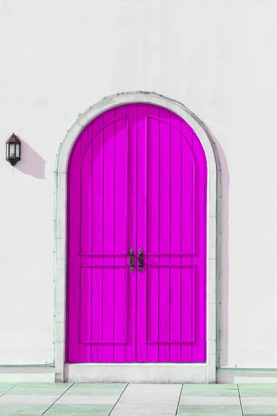 Colorful wooden purple door and Detail of house exterior on white wall.