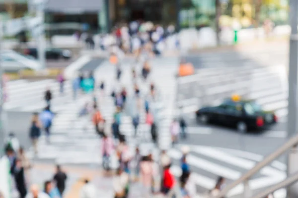 Abstract blurred people crossing the street outside at Nagoya station in Japan