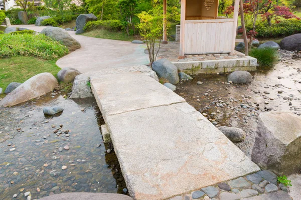 Stone path in a Japanese Garden, stone bridge, across a tranquil pond.