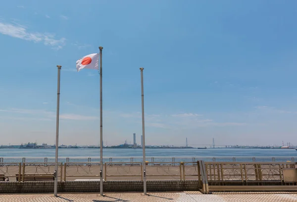 Japanese flag post with landscape of sea and sky background.