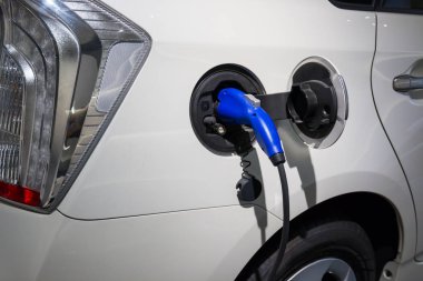 Elektrikli araba şarj ediliyor. Elektrikli bir otomobilin güç kaynağı takılı olarak şarj edilmesi..