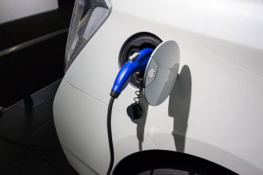 Elektrikli araba şarj ediliyor. Elektrikli bir otomobilin güç kaynağı takılı olarak şarj edilmesi..