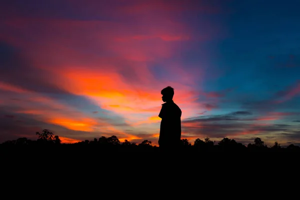 Silhouette of a male holding hands at sunrise, and happy winning