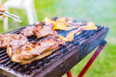 Parktaki festivalde barbeküde et pişirmek. Aileler ve arkadaşlarla yaz partisi kavramı.