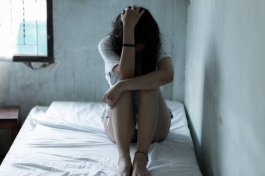 Asyalı kız umutsuz konsept uyuşturucu bağımlısı hissini kullandıktan sonra dalgın, yalnız kız konsepti karanlık odada