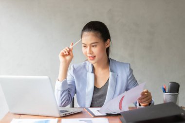 Evde çalışan Asyalı iş kadını laptoptan bilgi alıyor. İş, finans ve teknoloji kavramı.