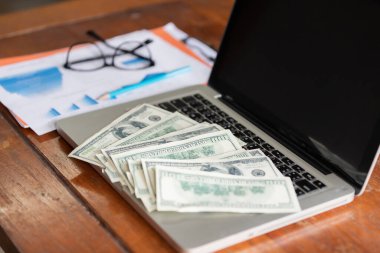 Bilgisayarı ve tahtadan parası olan bir ofis işyeri. Ticari zenginlik kavramı.