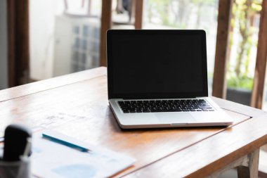 Ahşap masada dizüstü bilgisayarı olan bir ofis. Evden çalışma kavramı