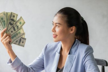 Başarılı bir Asyalı iş kadını. Elinde Amerikan doları banknotları, iş finans konsepti.