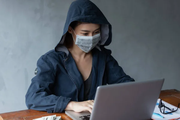 Hacker asia woman stealing data from online computer systems by using laptop. concept of business malware and hacker