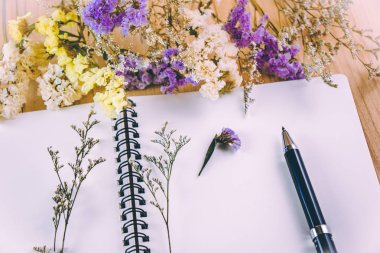 Ahşap masa üstünde boş defter koymak çiçek çiçek