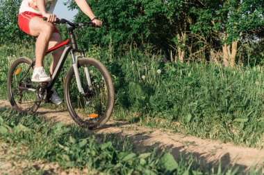 Bir adam beyaz spor ayakkabı bir bisiklet sürme