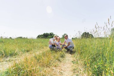 Aile alanına yürüyor. Sabun köpüğü ile. İki çocuklu bir aile. Aynı elbiseyle ailedir.