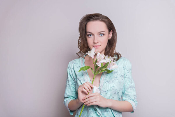 Woman with a flower. Woman on white background. A girl is holding flowers in her hands on a white background.