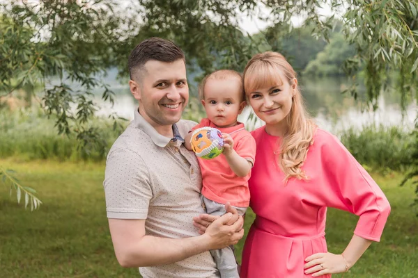 Family walk in the park. Family walks in the park. Man, woman and child in nature. Picture.