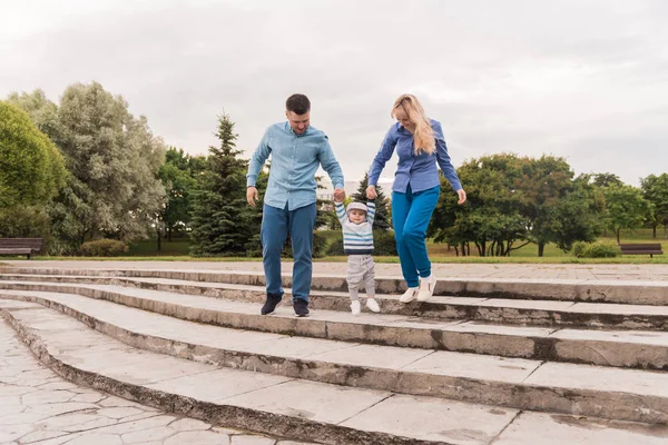 Family walk in the park. Family walks in the park. Man, woman and child in nature. Picture.