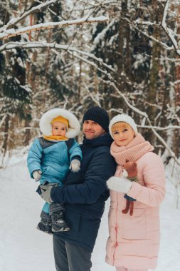 Bir çocuk ile aile yürüyüş. Aile doğada kış aylarında yürür. Doğada kış aile yürüyüş. Kar bir çok.