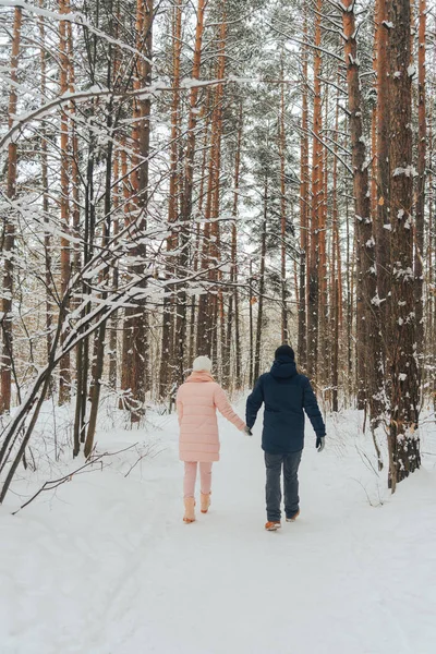 Любляча пара гуляє в лісі. Сімейна прогулянка в зимовому лісі — стокове фото