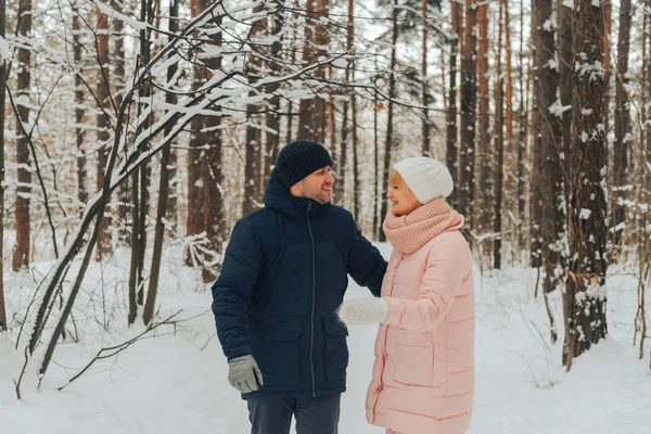 A loving couple walks in the woods. Family walk in the winter forest