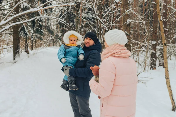 Caminar en familia con un niño. Los paseos familiares en la naturaleza en invierno. Paseo familiar de invierno en la naturaleza. Mucha nieve. . — Foto de Stock
