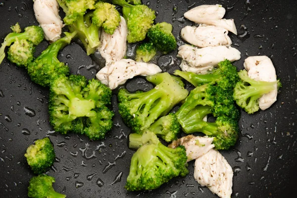 Brokuły smażyć na patelni z kawałkami mięsa. Mięso z kurczaka z brokułami. — Zdjęcie stockowe