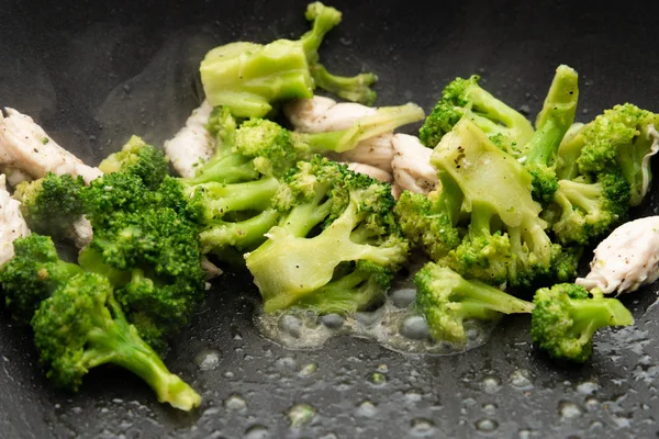 Brokuły smażyć na patelni z kawałkami mięsa. Mięso z kurczaka z brokułami. — Zdjęcie stockowe