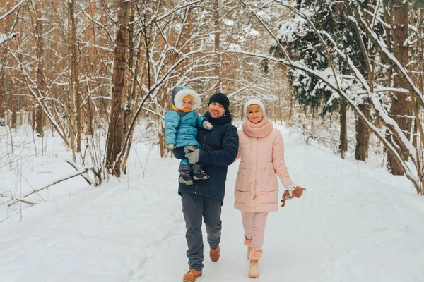 Walking family with a child. Family walks in nature in winter. Winter family walk in nature. A lot of snow. Stock Photo