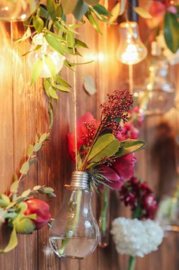 Rustik düğün fotoğraf bölge. El yapımı düğün süslemeleri Photo Booth kırmızı çiçekler içerir. Çelenk ve ampulleri