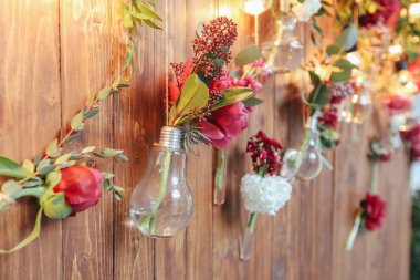 Rustik düğün fotoğraf bölge. El yapımı düğün süslemeleri Photo Booth kırmızı çiçekler içerir. Çelenk ve ampulleri