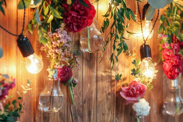 Rustic wedding photo zone. Hand made wedding decorations includes Photo Booth  red flowers. Garlands and light bulbs