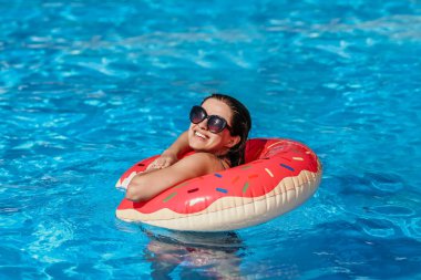 Pembe çörek daire olan güzel kadın var dinlenme mavi yüzme havuzunda