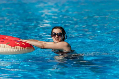 Pembe çörek daire olan güzel kadın var dinlenme mavi yüzme havuzunda