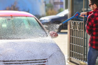 El ile araba yıkama oto yıkama dışında basınçlı su ile. Summe çamaşır. Yüksek basınçlı su kullanarak araba temizlik. Sabunla yıkama araba. Kavram kapatın.