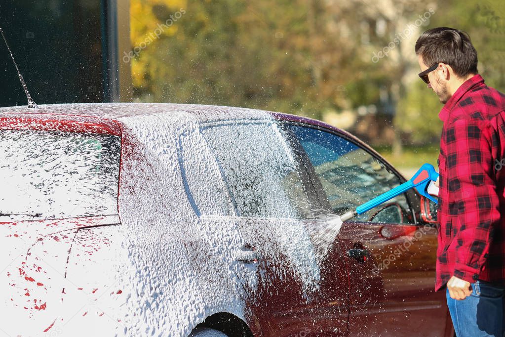 Manual car wash with pressurized water in car wash outside.Summe Washing. Cleaning Car Using High Pressure Water. Washing car with soap. Close up concept.