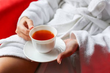 Güzel bir kadın portresi otel odasında sabah çay içme bornoz giymiş. 