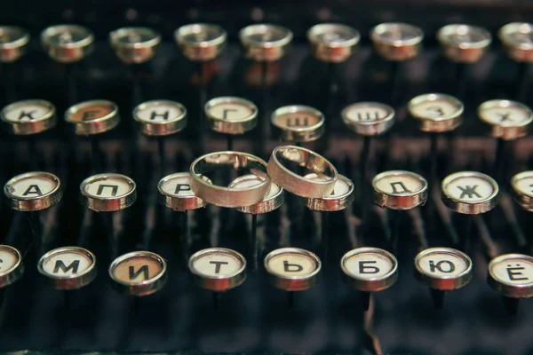 タイプライターの結婚指輪 結婚指輪は 古代タイプライター文字ボタン上に配置 — ストック写真