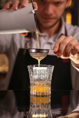Barmen alkol kokteyl yapmak. Taze alkol penisilin portakal dilimi ve buz küpleri ile kokteyl