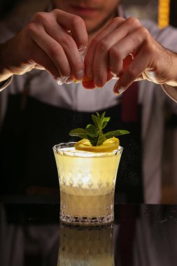  Barmen Fitzgerald kokteyl yapıyor. Fitzgerald alkol siyah zemin yüzeyinde kokteyl