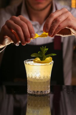  Barmen Fitzgerald kokteyl yapıyor. Fitzgerald alkol siyah zemin yüzeyinde kokteyl