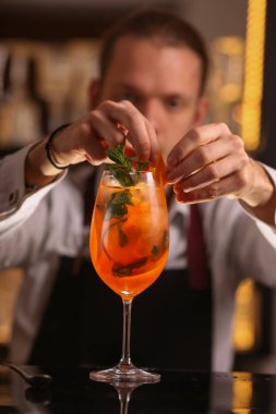 Barmen Aperol Spritz kokteyl yapıyor. Alkol arka plan siyah yüzey üzerinde kokteyl