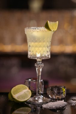 Margarita alkol kireç buzla kokteyl. Alkol arka plan siyah yüzey üzerinde kokteyl. Barmen Margarita yapıyor