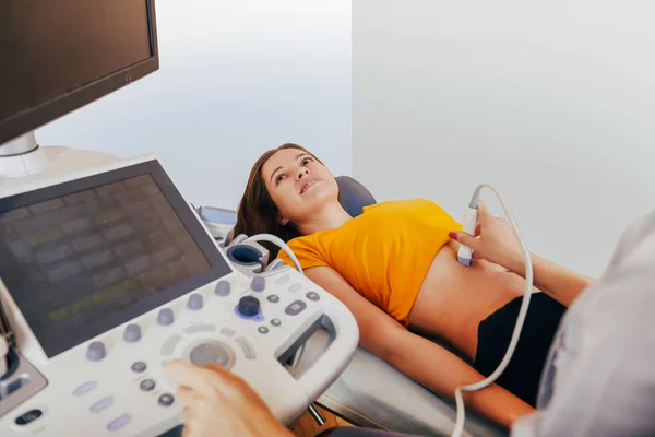 Doktor hasta yapıyor kadın abdominal ultrason. Ultrason tarayıcı bir doktor elinde. Tanılama. Ultrason 